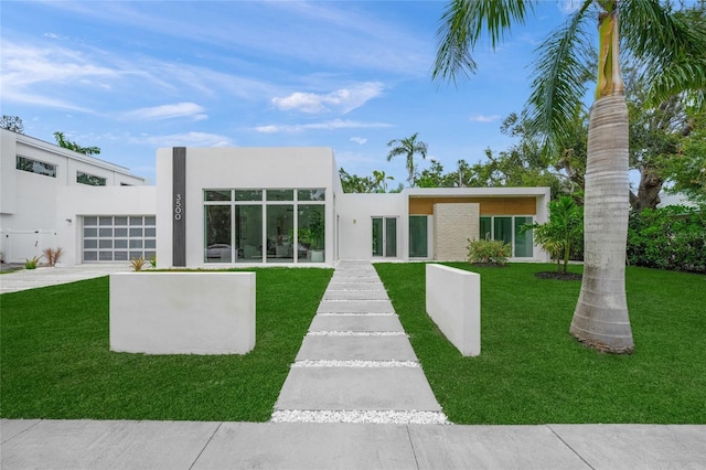 3500 Bay Shore Rd, Sarasota, FL 34234 - rear view of property featuring stucco siding, a garage, a yard, and concrete driveway