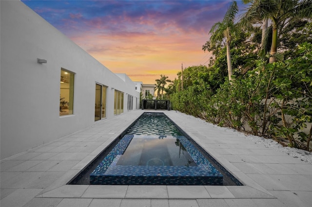3500 Bay Shore Rd, Sarasota, FL 34234 - pool at dusk featuring an in-ground hot tub and an outdoor pool