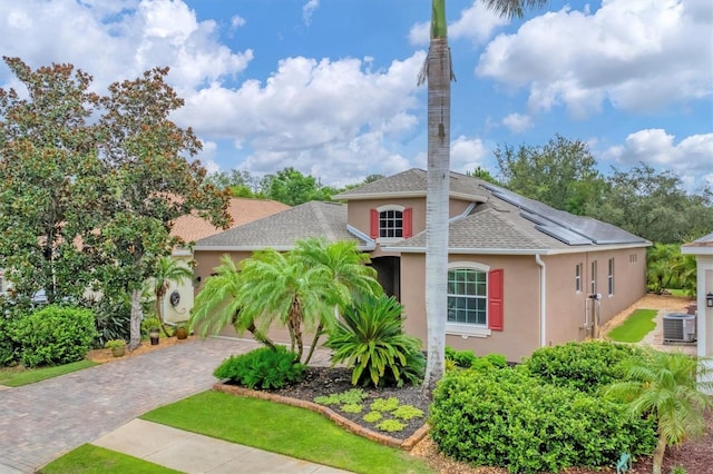 6305 Golden Eye Gln, Lakewood Ranch, FL 34202 - view of front of house featuring stucco siding, decorative driveway, solar panels, a shingled roof, and a garage