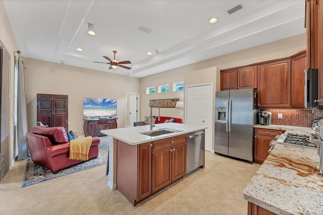6305 Golden Eye Gln, Lakewood Ranch, FL 34202 - kitchen with stainless steel appliances, a raised ceiling, light countertops, decorative backsplash, and open floor plan