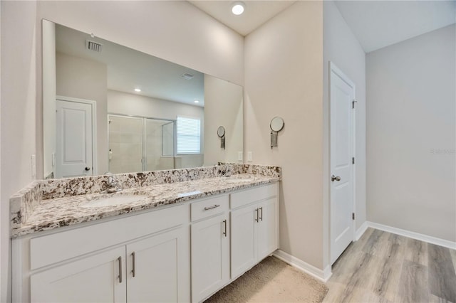 12357 Nantahala Run, Parrish, FL 34219 - bathroom with double vanity, a shower stall, and wood finished floors