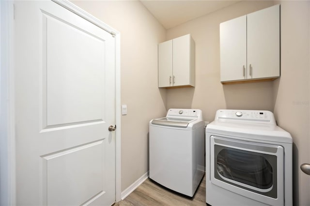 12357 Nantahala Run, Parrish, FL 34219 - washroom featuring washing machine and clothes dryer, cabinet space, and light wood-style floors
