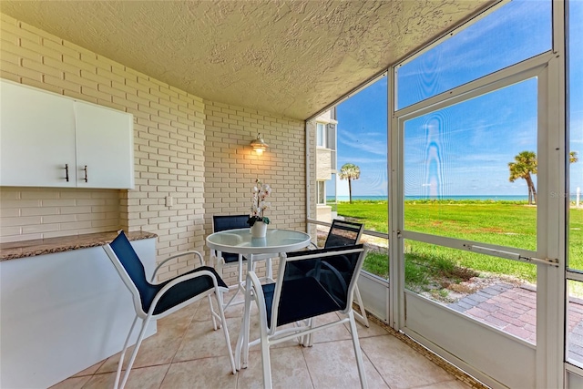 4805 Gulf Of Mexico Dr Unit 105, Longboat Key, FL 34228 - sunroom / solarium featuring a water view and healthy amount of natural light