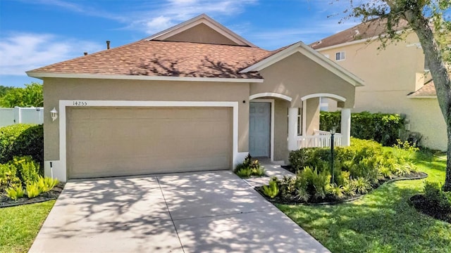 14255 Gnatcatcher Ter, Lakewood Ranch, FL 34202 - view of front of house with a shingled roof, an attached garage, stucco siding, and concrete driveway