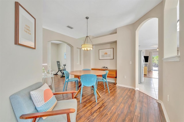 14255 Gnatcatcher Ter, Lakewood Ranch, FL 34202 - dining area with arched walkways and wood finished floors