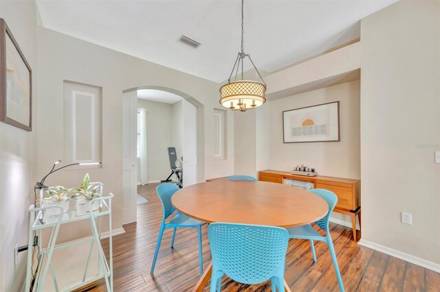 14255 Gnatcatcher Ter, Lakewood Ranch, FL 34202 - dining area with arched walkways and wood finished floors
