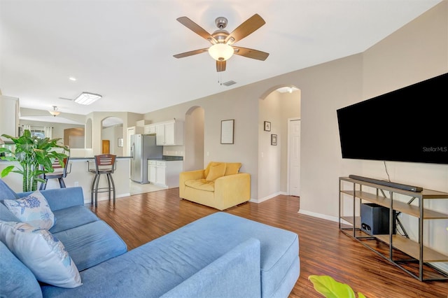 14255 Gnatcatcher Ter, Lakewood Ranch, FL 34202 - living room with arched walkways, light wood-type flooring, and a ceiling fan