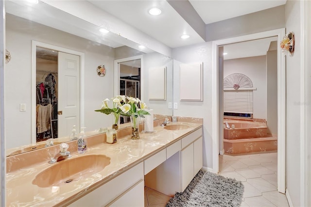 80 Rio Cuarto St, Punta Gorda, FL 33983 - bathroom featuring a garden tub, double vanity, recessed lighting, a walk in closet, and tile patterned floors
