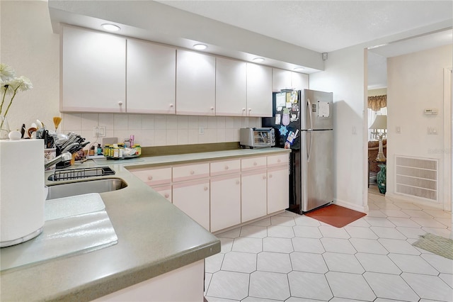 80 Rio Cuarto St, Punta Gorda, FL 33983 - kitchen featuring decorative backsplash, light countertops, freestanding refrigerator, white cabinetry, and recessed lighting