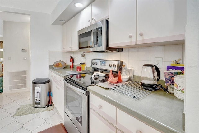 80 Rio Cuarto St, Punta Gorda, FL 33983 - kitchen featuring appliances with stainless steel finishes, decorative backsplash, white cabinetry, and light countertops