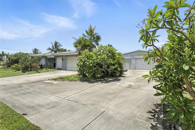 326 Mann Ave SE, Port Charlotte, FL 33952 - obstructed view of property with driveway, an attached garage, and stucco siding