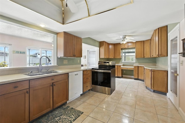 326 Mann Ave SE, Port Charlotte, FL 33952 - kitchen with dishwasher, electric stove, ceiling fan, brown cabinetry, and light countertops