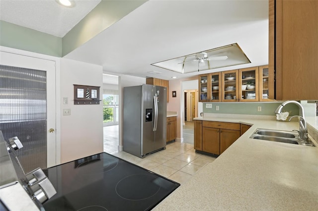 326 Mann Ave SE, Port Charlotte, FL 33952 - kitchen featuring stainless steel fridge, brown cabinetry, a tray ceiling, light countertops, and light tile patterned floors