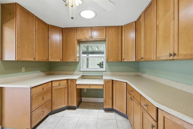 326 Mann Ave SE, Port Charlotte, FL 33952 - kitchen with light tile patterned flooring, brown cabinets, light countertops, and a ceiling fan