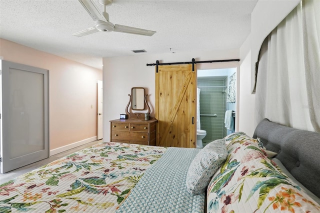 326 Mann Ave SE, Port Charlotte, FL 33952 - bedroom featuring a barn door, a textured ceiling, ensuite bathroom, and a ceiling fan