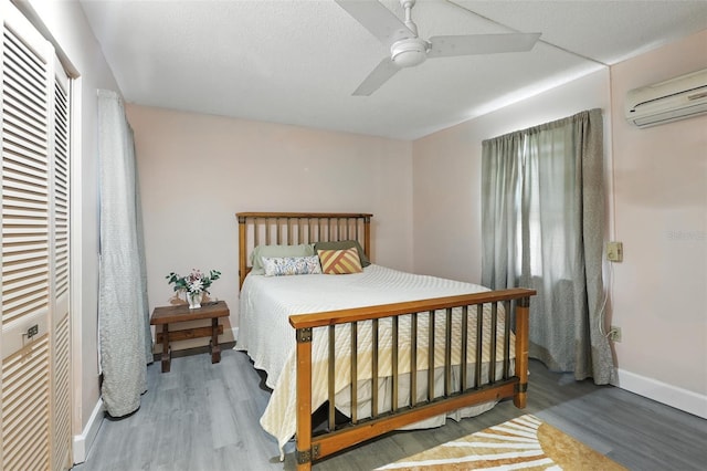 326 Mann Ave SE, Port Charlotte, FL 33952 - bedroom featuring a wall unit AC, wood finished floors, and ceiling fan