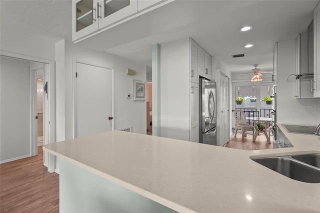 3705 E Bay Dr Unit 205, Holmes Beach, FL 34217 - kitchen featuring stainless steel fridge, light countertops, recessed lighting, light wood-type flooring, and ceiling fan