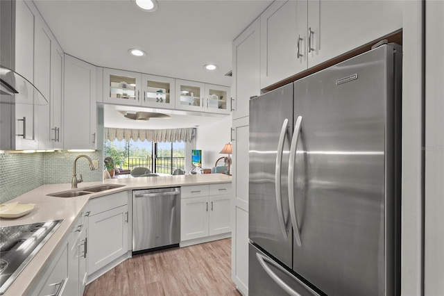 3705 E Bay Dr Unit 205, Holmes Beach, FL 34217 - kitchen featuring stainless steel appliances, white cabinetry, light wood-style flooring, glass insert cabinets, and recessed lighting