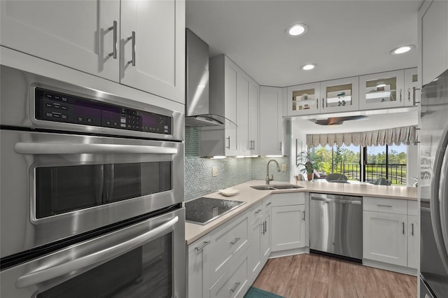 3705 E Bay Dr Unit 205, Holmes Beach, FL 34217 - kitchen with appliances with stainless steel finishes, wall chimney range hood, light countertops, recessed lighting, and white cabinets