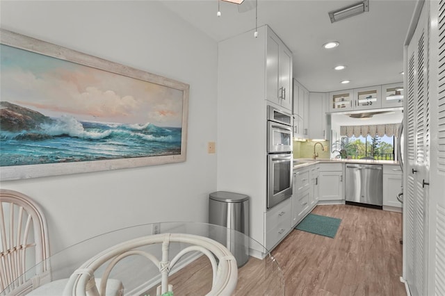 3705 E Bay Dr Unit 205, Holmes Beach, FL 34217 - kitchen featuring stainless steel appliances, recessed lighting, light wood-style flooring, tasteful backsplash, and light countertops