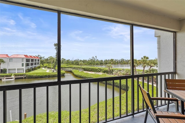 3705 E Bay Dr Unit 205, Holmes Beach, FL 34217 - unfurnished sunroom with a water view and plenty of natural light