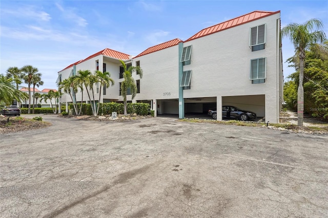 3705 E Bay Dr Unit 205, Holmes Beach, FL 34217 - view of property with driveway and a carport