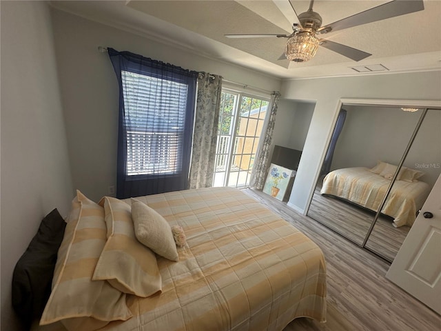 8809 White Sage Loop, Lakewood Ranch, FL 34202 - bedroom featuring wood finished floors, a tray ceiling, and ceiling fan