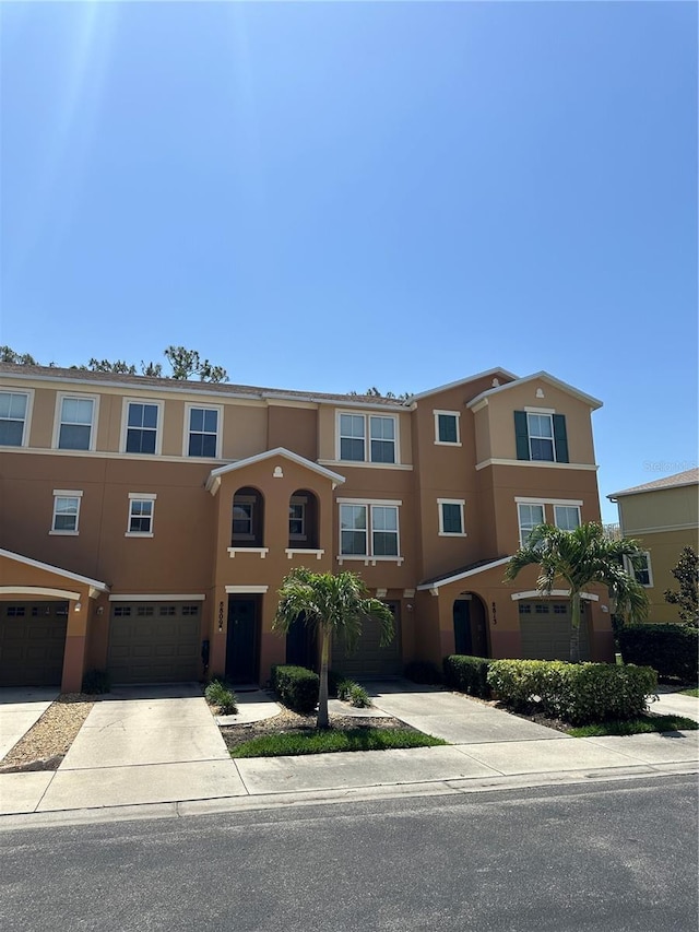 8809 White Sage Loop, Lakewood Ranch, FL 34202 - view of property featuring stucco siding, driveway, and a garage