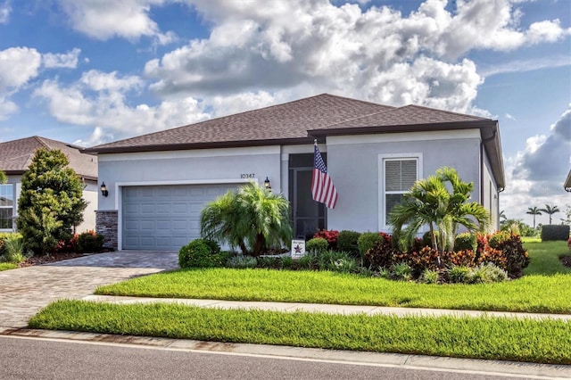10347 Coastal Shores Dr, Parrish, FL 34219 - ranch-style home featuring a garage, decorative driveway, stucco siding, and a front yard