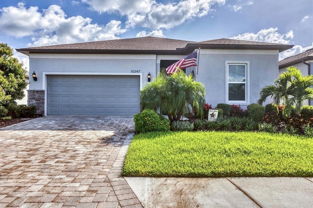 10347 Coastal Shores Dr, Parrish, FL 34219 - view of front of home with decorative driveway, stucco siding, a garage, and stone siding