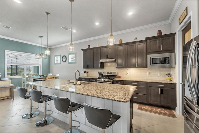 10347 Coastal Shores Dr, Parrish, FL 34219 - kitchen featuring stainless steel appliances, under cabinet range hood, backsplash, a kitchen bar, and light tile patterned flooring