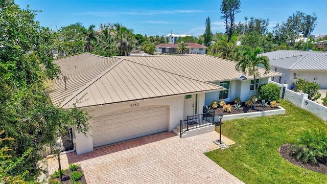 6962 Belgrave Dr, Sarasota, FL 34242 - view of front of home featuring a standing seam roof, driveway, stucco siding, a metal roof, and an attached garage