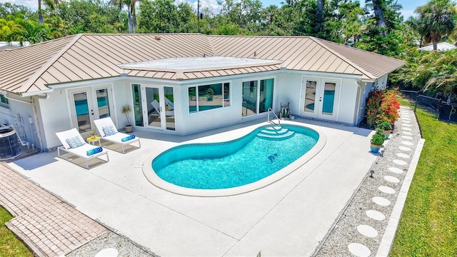 6962 Belgrave Dr, Sarasota, FL 34242 - rear view of property featuring french doors, a standing seam roof, and stucco siding