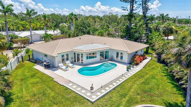 6962 Belgrave Dr, Sarasota, FL 34242 - rear view of house featuring a standing seam roof, stucco siding, a fenced backyard, and french doors