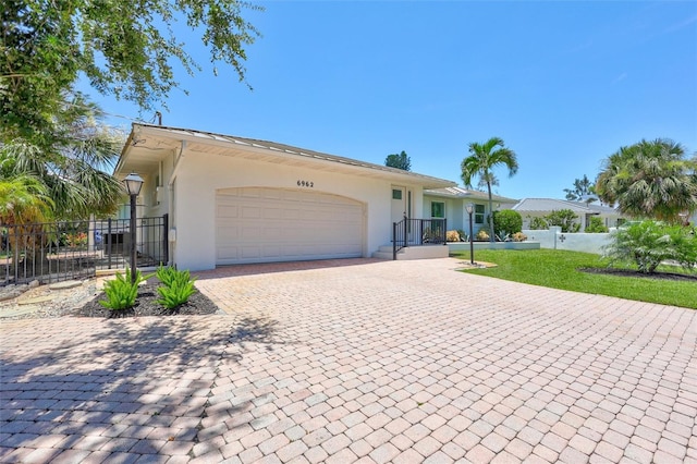 6962 Belgrave Dr, Sarasota, FL 34242 - ranch-style home featuring stucco siding, a garage, and decorative driveway