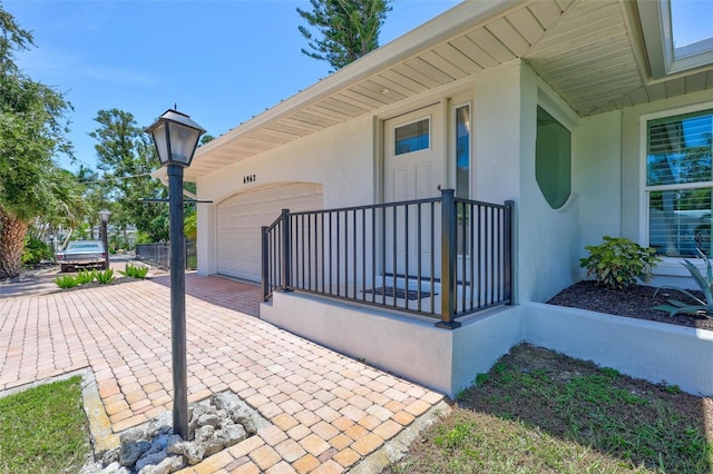 6962 Belgrave Dr, Sarasota, FL 34242 - entrance to property featuring an attached garage, decorative driveway, and stucco siding