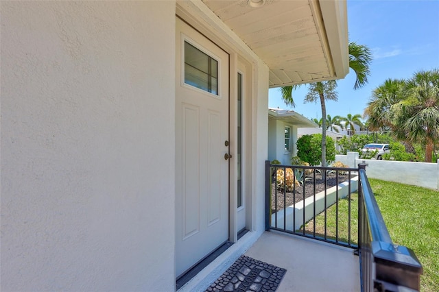 6962 Belgrave Dr, Sarasota, FL 34242 - view of exterior entry featuring stucco siding and a porch