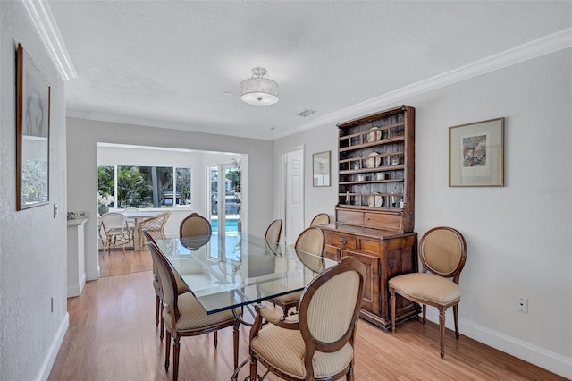 6962 Belgrave Dr, Sarasota, FL 34242 - dining area featuring light wood-style floors and ornamental molding