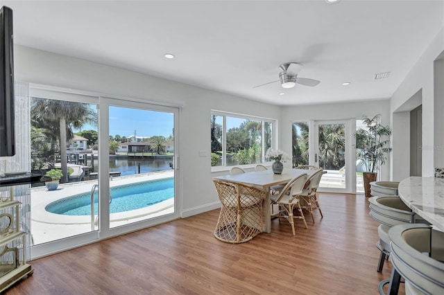 6962 Belgrave Dr, Sarasota, FL 34242 - dining space with a ceiling fan, wood finished floors, recessed lighting, and a water view