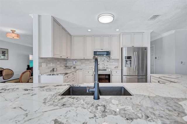 6962 Belgrave Dr, Sarasota, FL 34242 - kitchen with appliances with stainless steel finishes, ornamental molding, light stone counters, decorative backsplash, and white cabinetry