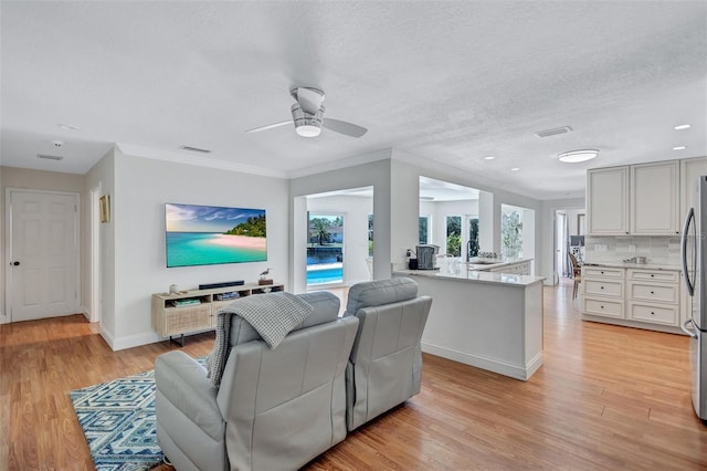 6962 Belgrave Dr, Sarasota, FL 34242 - living area featuring light wood-style floors, a ceiling fan, and a textured ceiling