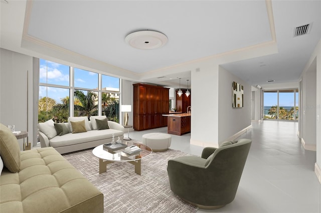 2251 Gulf Of Mexico Dr Unit 301, Longboat Key, FL 34228 - living room with plenty of natural light, ornamental molding, light tile patterned floors, and a tray ceiling