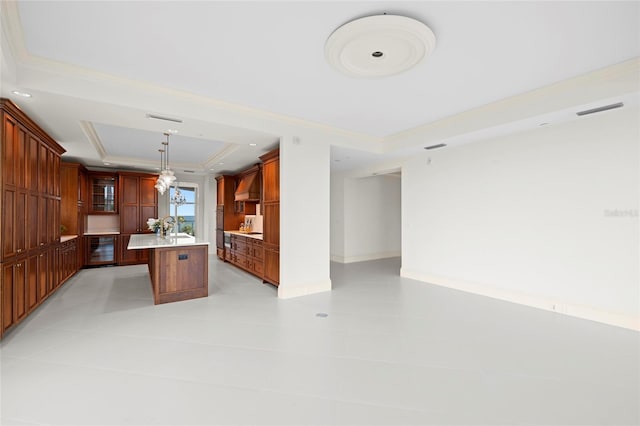 2251 Gulf Of Mexico Dr Unit 301, Longboat Key, FL 34228 - kitchen featuring a tray ceiling, ornamental molding, a kitchen island with sink, custom exhaust hood, and wine cooler