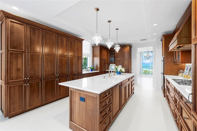2251 Gulf Of Mexico Dr Unit 301, Longboat Key, FL 34228 - kitchen with a raised ceiling, light countertops, an island with sink, hanging light fixtures, and glass insert cabinets
