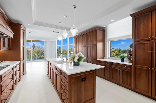 2251 Gulf Of Mexico Dr Unit 301, Longboat Key, FL 34228 - kitchen with an island with sink, light countertops, pendant lighting, crown molding, and a tray ceiling