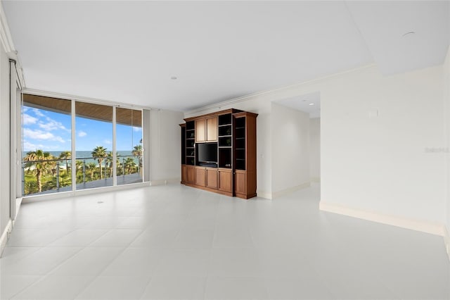 2251 Gulf Of Mexico Dr Unit 301, Longboat Key, FL 34228 - unfurnished living room featuring expansive windows, light tile patterned flooring, and crown molding