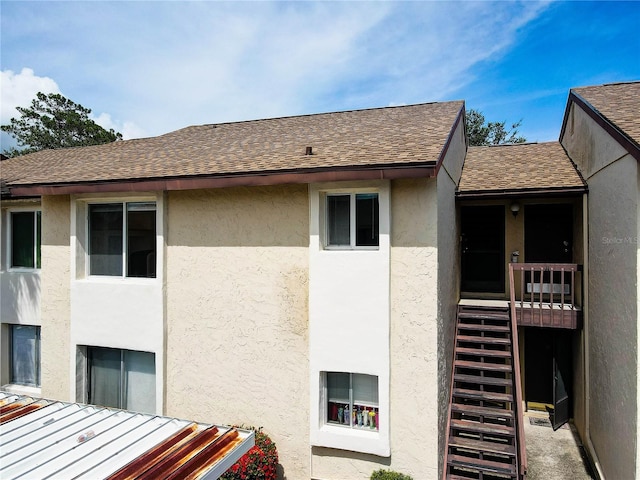 2716 Hidden Lake Blvd Unit C, Sarasota, FL 34237 - view of side of home with stucco siding, a shingled roof, a standing seam roof, and stairway