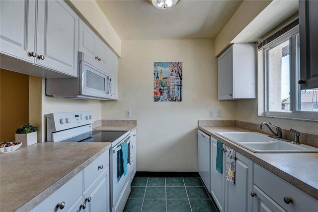 2716 Hidden Lake Blvd Unit C, Sarasota, FL 34237 - kitchen with white appliances, white cabinetry, dark tile patterned floors, and light countertops