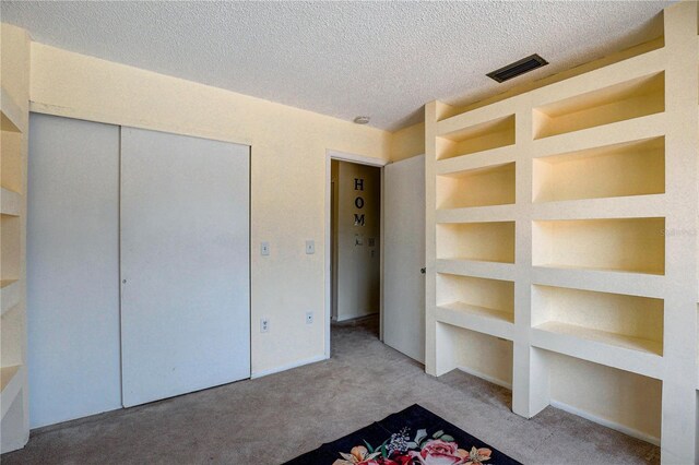 2716 Hidden Lake Blvd Unit C, Sarasota, FL 34237 - unfurnished bedroom featuring carpet, a textured ceiling, and a closet