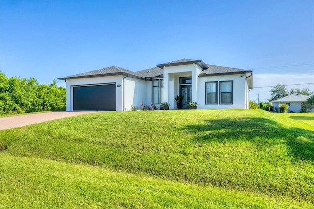 10270 Castanet Ave, Englewood, FL 34224 - prairie-style home featuring an attached garage, driveway, a front lawn, and stucco siding